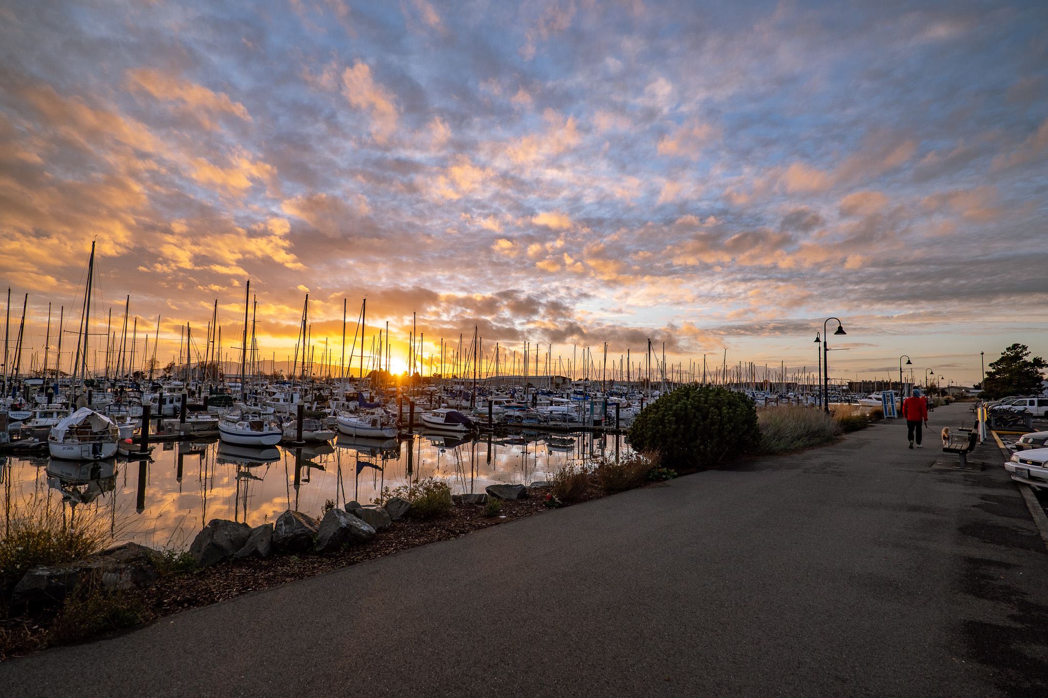 the  promenade at sunset showing a colorful sky and sailboats